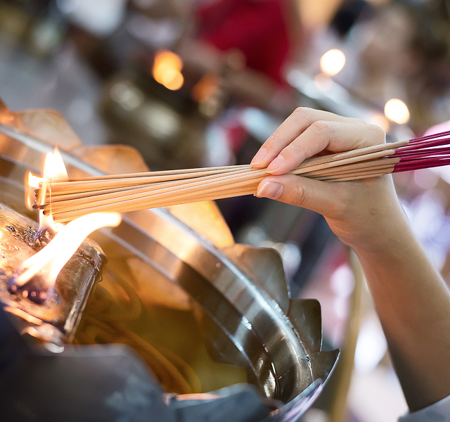 a person lighting incense