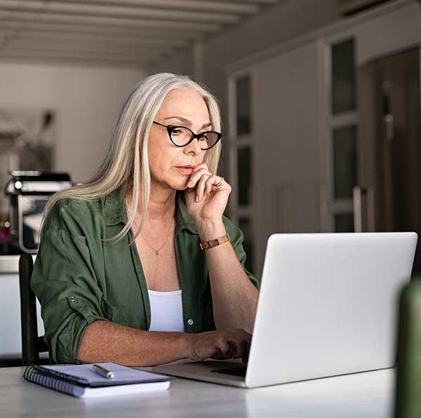 a woman looking at her laptop